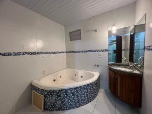 a bathroom with a bath tub and a sink at Hotel Concha do Mar in Salinópolis +68 photos
