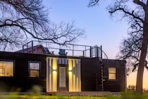 a house with lights on the front of it at The Blue Ridge "Romantic" Tiny Home Near Magnolia & Baylor in Bellmead