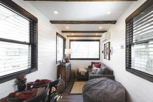 een woonkamer met een bank en een tafel en stoelen bij The Blue Ridge "Romantic" Tiny Home Near Magnolia & Baylor in Bellmead