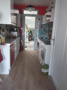 a kitchen with white appliances and a wooden floor at Une chambre presque en ville in Quimper +2 photos