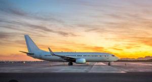 an airplane sitting on an airport runway at sunset at Modern apartment next to airport in Marston Green