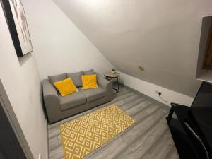 una pequeña sala de estar con sofá y alfombra en Modern apartment next to airport, en Marston Green