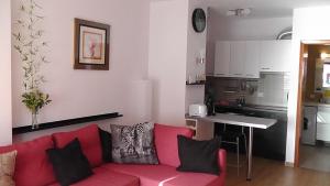 Ocean Park في أديخي: غرفة معيشة مع أريكة حمراء ومطبخ
