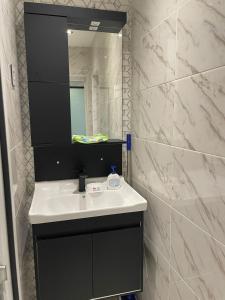 een badkamer met een wastafel en een spiegel bij OZAN LUXHOUSE in Ganja