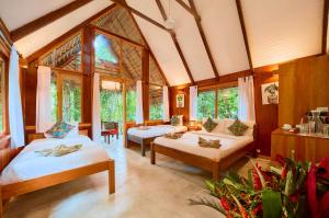 a large room with two beds and windows at Hotel Shawandha Costa Rica in Puerto Viejo +126 photos