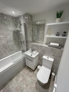 a bathroom with a toilet and a sink and a tub at Apartment in Ashford with Large Terrace in Ashford
