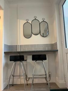 two mirrors on a wall above a counter with two stools at City Of Chester Award Winning Cottage -Pixie Terrace Chester in Chester