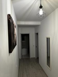 a hallway with a white room with a light fixture at Best Apartment Suceava in Suceava +44 photos