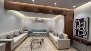 uma sala de estar com sofás e uma mesa em شاليه العنود في ملهم em Ruwayqah