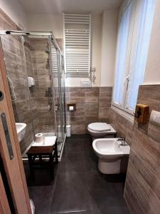 uma casa de banho com 2 WC, um chuveiro e um lavatório. em La Taverna del Metallo Rooms em La Spezia