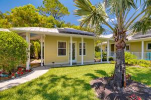 a yellow house with a palm tree in the yard at Riverfront Florida Studio with Pool and Hot Tub Access in La Belle
