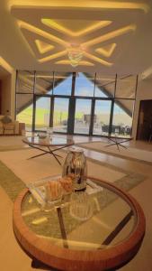 um quarto com uma mesa de vidro com óculos em شاليه العنود في ملهم em Ruwayqah