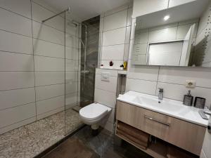 La salle de bains est pourvue de toilettes, d'un lavabo et d'une douche. dans l'établissement Modern Apartment, à Augsbourg