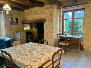 a dining room with a table and a fireplace at La Riviere Esperance in Veyrignac