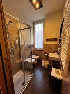 a bathroom with a shower and a toilet and a sink at La Taverna del Metallo Rooms in La Spezia