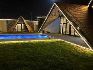 uma casa com piscina à noite em شاليه العنود في ملهم em Ruwayqah
