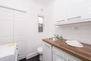 een witte badkamer met een wastafel en een toilet bij London House in Londen