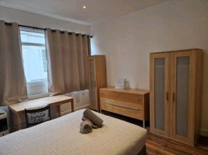 Affordable Rooms in shared flat, London Bridge في لندن: غرفة نوم بسريرين وخزانة ونافذة