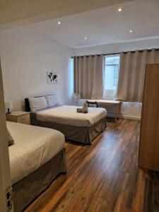 Affordable Rooms in shared flat, London Bridge في لندن: غرفة فندقية بسريرين ونافذة