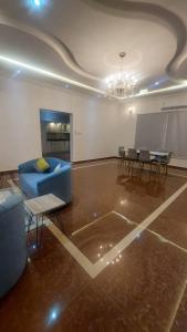 شقق جدة دستنيشن في جدة: غرفة معيشة مع أريكة زرقاء وطاولة