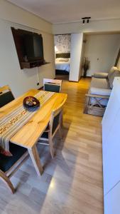 een woonkamer met een houten tafel en een slaapkamer bij Apartamento Urquiza in Bariloche