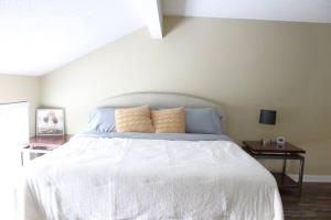 a bedroom with a white bed with two tables at Condo in Downtown Little Rock in Little Rock
