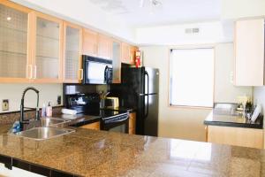 a kitchen with a sink and a black refrigerator at Condo in Downtown Little Rock in Little Rock