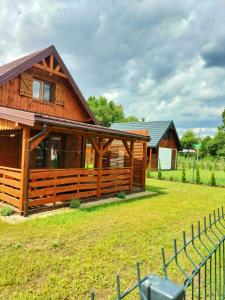 a log cabin with a fence in front of it at Domki Przydwórz in Przydwórz