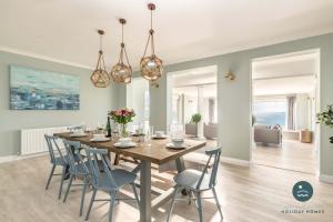 a dining room with a wooden table and chairs at Comfort Hill - Luxury hot tub views games room in Overcombe