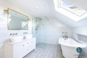 a white bathroom with two sinks and a tub at Comfort Hill - Luxury hot tub sea views in Overcombe +30 photos