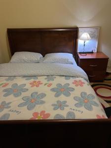 a bed with a blanket with flowers on it at Comfortable room in Riverside in Riverside