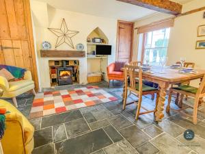 a living room with a table and a fireplace at Rope Cottage - traditional cottage close to town in Bridport