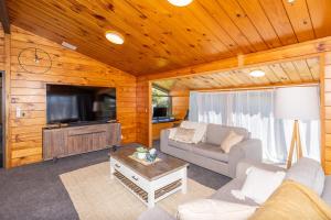 a living room with a couch and a tv at Handy to Hospital. in Hamilton