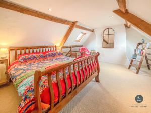 sypialnia z drewnianym łóżkiem na poddaszu w obiekcie Rope Cottage - traditional cottage close to town w mieście Bridport