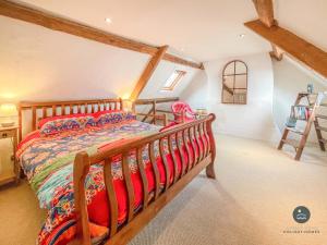 a bedroom with a wooden bed in a attic at Rope Cottage - traditional cottage close to town in Bridport