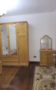 a room with wooden cabinets and a mirror at Kerlos house in 6th Of October