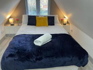 a large bed with a white pillow on it at Modern apartment next to airport in Marston Green