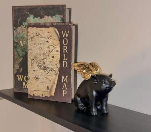 a figurine of a black pig with a butterfly on a shelf at Central Winchester Serviced Apartments in Winchester