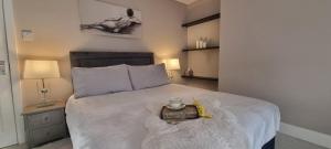 Un dormitorio con una gran cama blanca y una bandeja. en Central Winchester Serviced Apartments, en Winchester