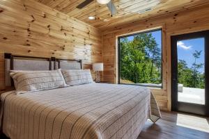 ein Schlafzimmer mit einem Bett und einem großen Fenster in der Unterkunft Grand Vista View- Breathtaking Views, FREE tickets for each paid day, Hot Tub, WIFI in Sevierville