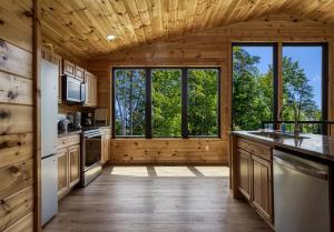 eine Küche mit Holzvertäfelung und großen Fenstern in der Unterkunft Grand Vista View- Breathtaking Views, FREE tickets for each paid day, Hot Tub, WIFI in Sevierville