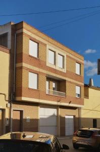 Apartamento Novo en Montealegre amplio y comodo في Montealegre del Castillo: مبنى من الطوب مع سيارة متوقفة أمامه