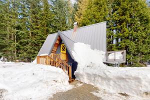 a cabin in the woods with snow around it at Alpine Modern A-Frame in Snoqualmie Pass