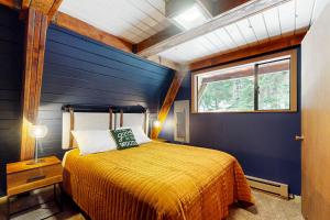 Alpine Modern A-Frame في Snoqualmie Pass: غرفة نوم بسرير اصفر في جدار ازرق