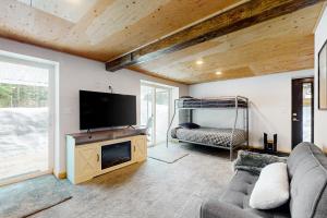 a living room with a flat screen tv and a couch at Alpine Modern A-Frame in Snoqualmie Pass