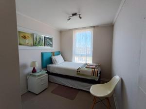 a small bedroom with a bed and a window at APART LOMAS DE SAN ANDRES concepción in Concepción