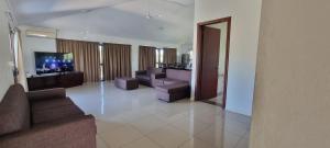 a living room with couches and a flat screen tv at Large 4 bedroom villa with Pool in Sonaisali Nadi in Nadi