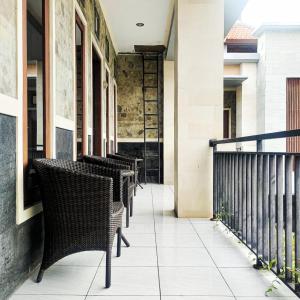 une rangée de tables et de chaises sur un balcon dans l'établissement Santhi Graha by NauliTabitha, à Legian