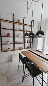uma sala de jantar com uma mesa de madeira e cadeiras pretas em Think Home, exploring the center of Thessaloniki em Tessalónica