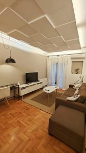 uma sala de estar com um sofá e uma televisão em Think Home, exploring the center of Thessaloniki em Tessalônica